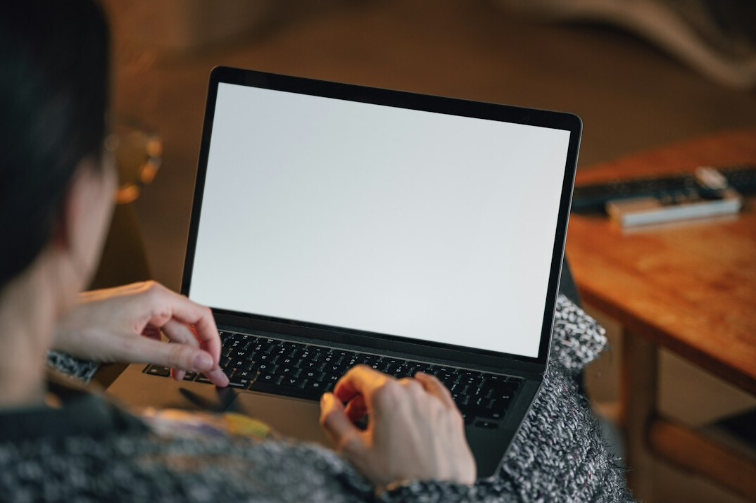 person searching on laptop at home